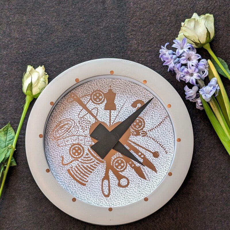 Plottdatei mit Nähmotiven (Schere, Knopf, Garnrolle, Schneiderpuppe) kreisförmig um ein Herz, dargestellt als Zifferblatt einer Uhr.