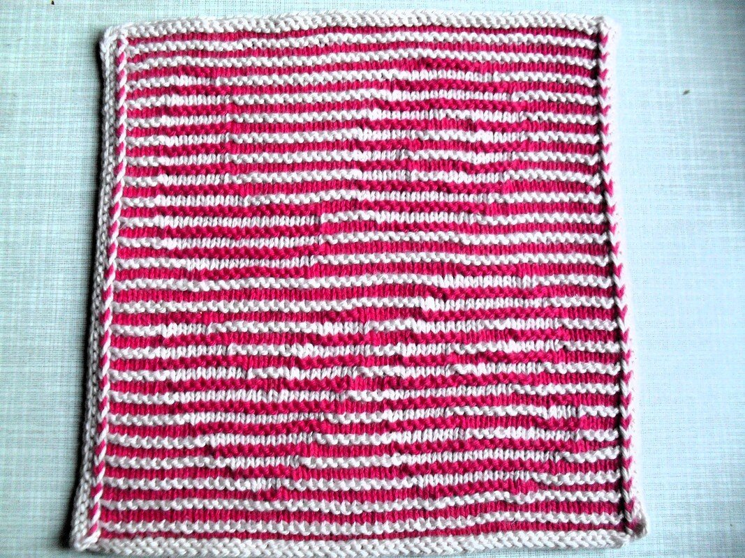 Quadratisches gestricktes Stück mit rosa-weißen Streifen und weißem Rand