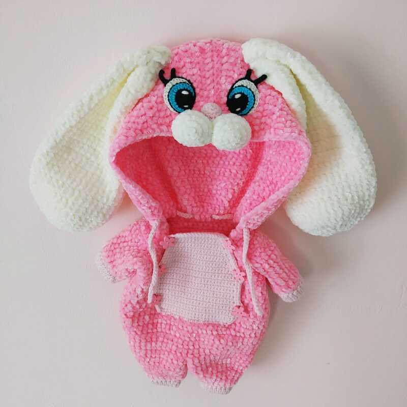Pink crocheted bunny outfit with hood, long white ears, embroidered blue eyes and pom-pom nose.