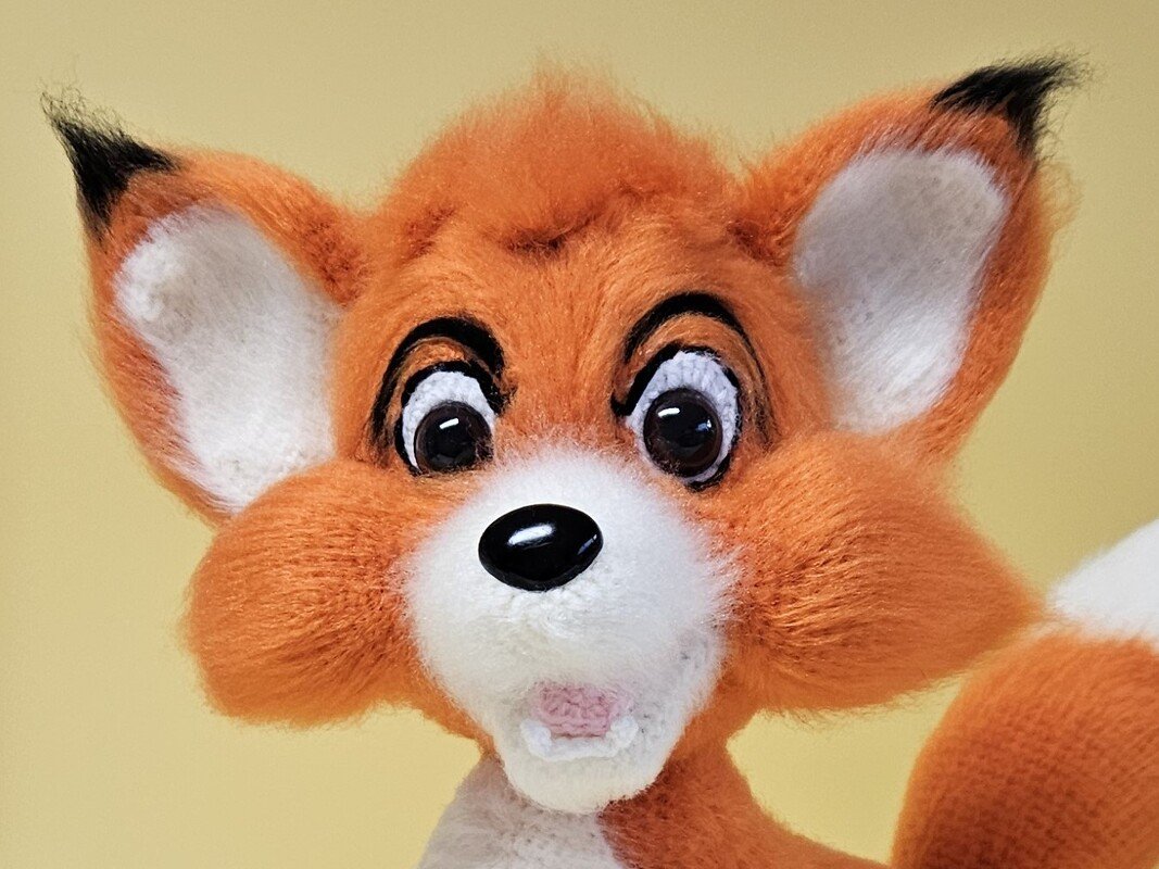 Frontalansicht eines niedlichen roten Amigurumi-Fuchses mit weißer Schnauze