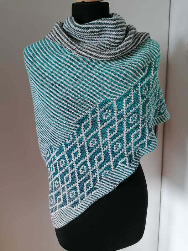 Gestricktes Dreieckstuch in Petrol und Hellgrau mit diagonalen Streifen und Rautenmuster auf einer schwarzen Schaufensterpuppe.
