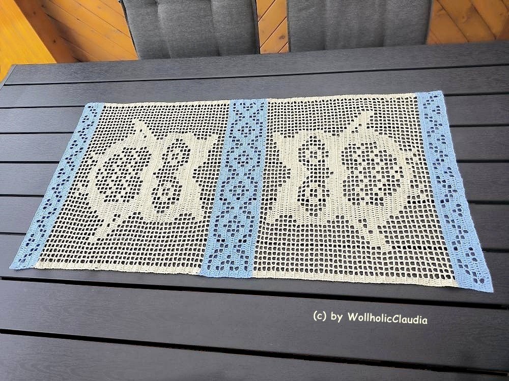 Filet‑gehäkelter Tischläufer in Creme mit hellblauen Rändern und symmetrischen Ornamenten