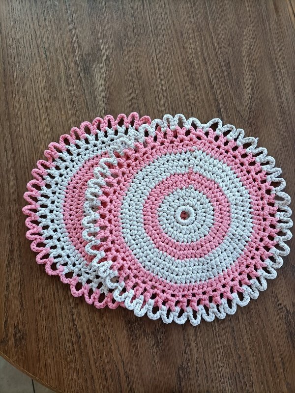 Zwei gleichgroße runde Häkeldeckchen in Rosa und Weiß als Musteridee