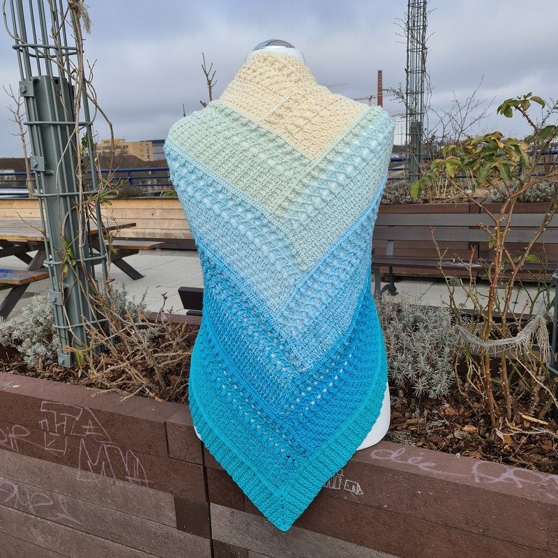 Triangle crochet shawl on mannequin, ombré cream to turquoise with textured stitch bands and eyelets