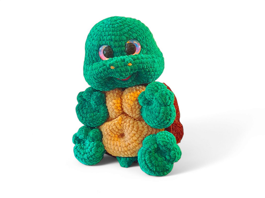 Bright green crocheted amigurumi turtle with tan belly and brown shell, sitting upright with glossy eyes.