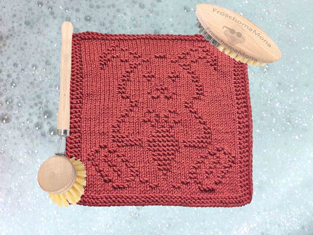 Quadratisches gestricktes Deckchen in Dunkelrot mit reliefartigem Osterhasen-Motiv, daneben Holzbürsten