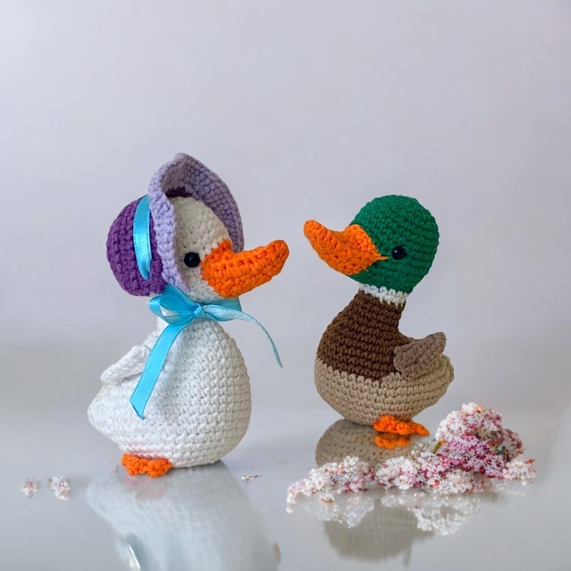 Zwei gehäkelte Amigurumi-Enten in Kontrastfarben mit sichtbarer Maschenstruktur