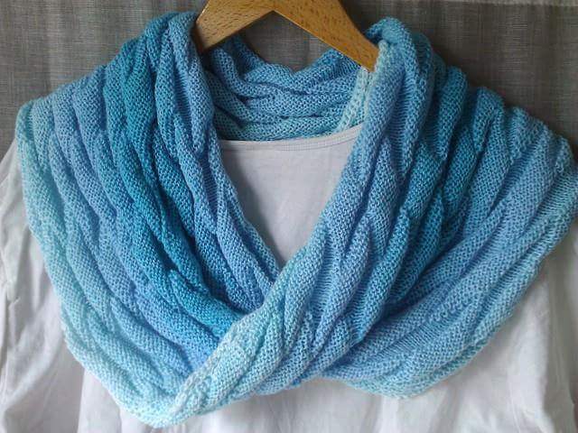 Gestrickter blauer Loop-Schal mit Farbverlauf auf Holzhänger über weißem Shirt