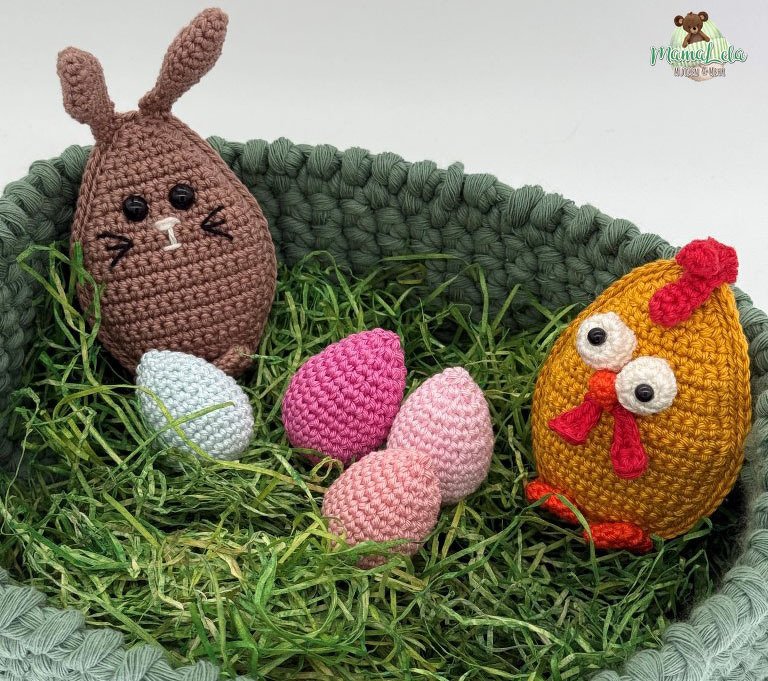 Grünes Häkel-Utensilo als Osternest mit Dekogras, vier Häkeleiern, eiförmigem Häkelhasen und Häkelhuhn.