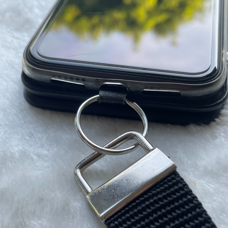 Detailaufnahme Bandende mit Metallklemme und Schlüsselring an Smartphonehülle