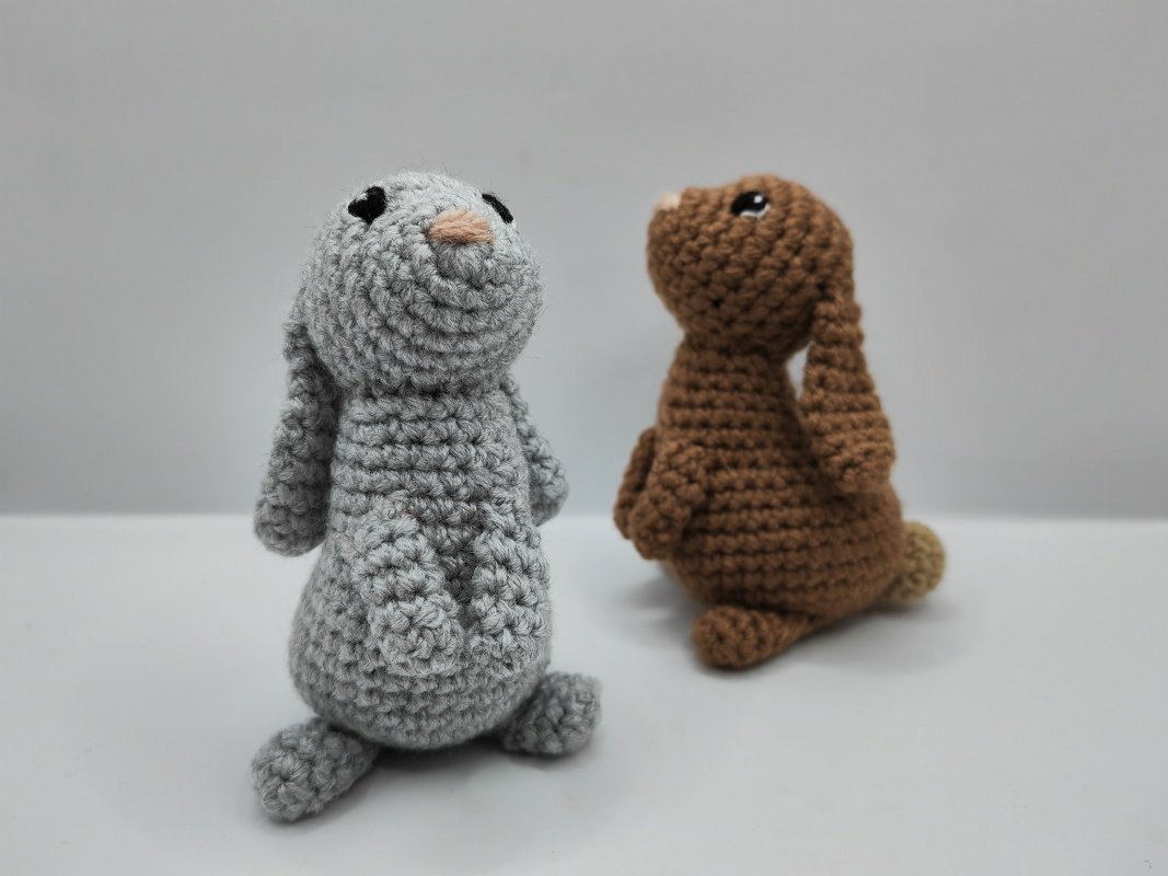 Gray and brown amigurumi rabbit pair with rounded bodies and long ears