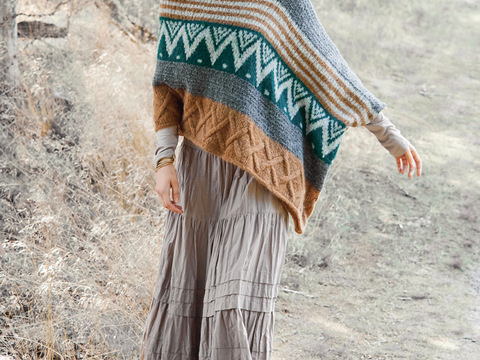 Breit gestreifter Poncho im Rauten-, Jacquard- und Reliefmuster gestrickt.