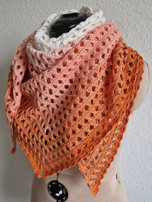 Gehäkeltes Dreieckstuch in Weiß, Rosé und Orange mit Ajour-Lochmuster an einer Schneiderpuppe