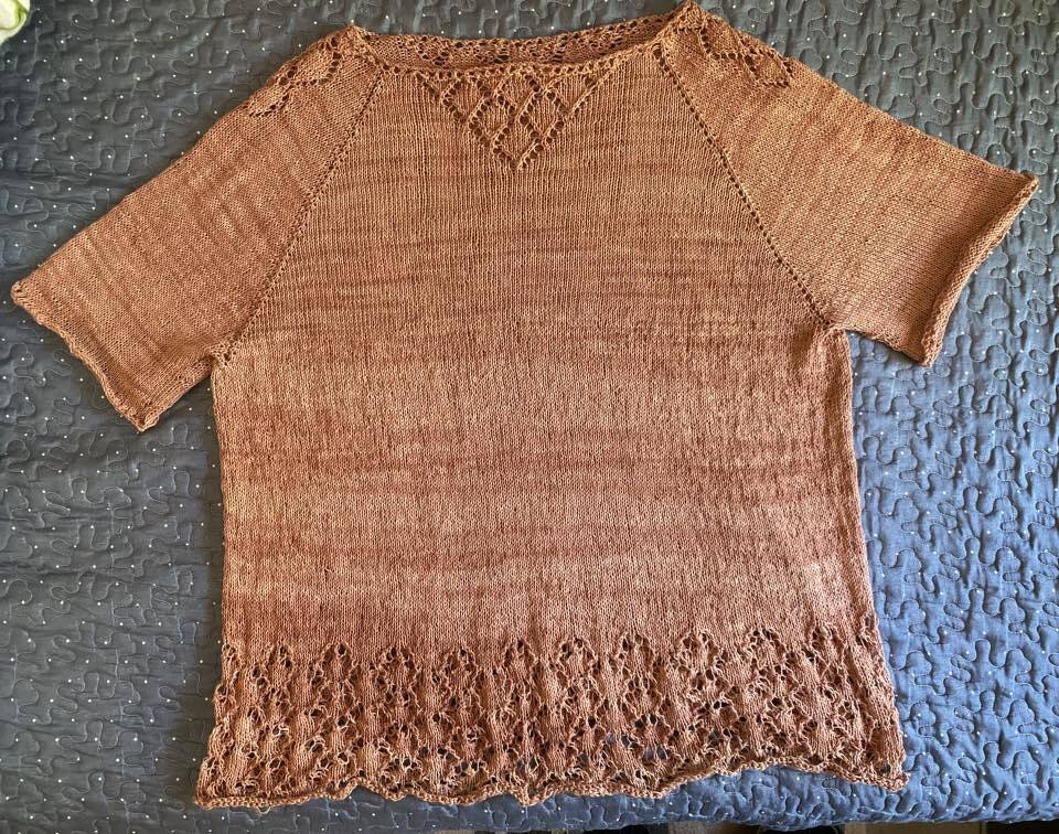 Rostbraunes gestricktes Damen-Shirt mit kurzen Raglanärmeln und Ajourmuster am Ausschnitt und Saum, flach ausgelegt