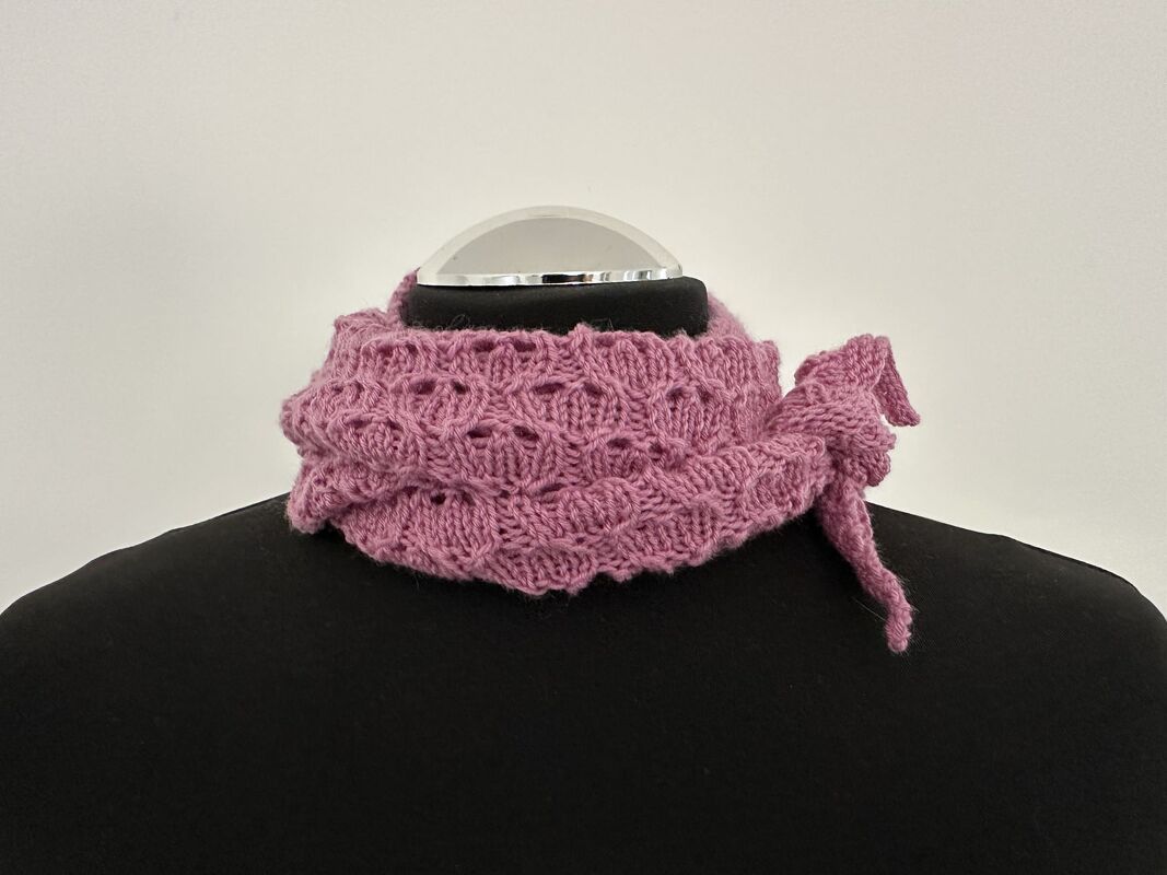 Altrosa gestricktes Lacetuch mit offenem Lacemuster auf schwarzer Büste