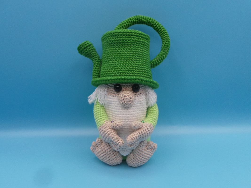 Nahaufnahme eines gehäkelten Wichtels mit grünem Hut und sichtbaren Maschen