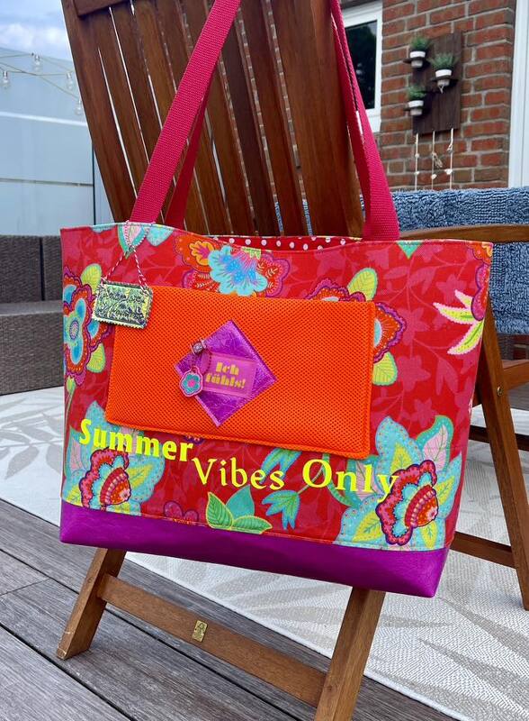 Bunte genähte Stoff-Einkaufstasche mit Blumenprint, orangener Außentasche, violettem Boden und roten Tragegriffen