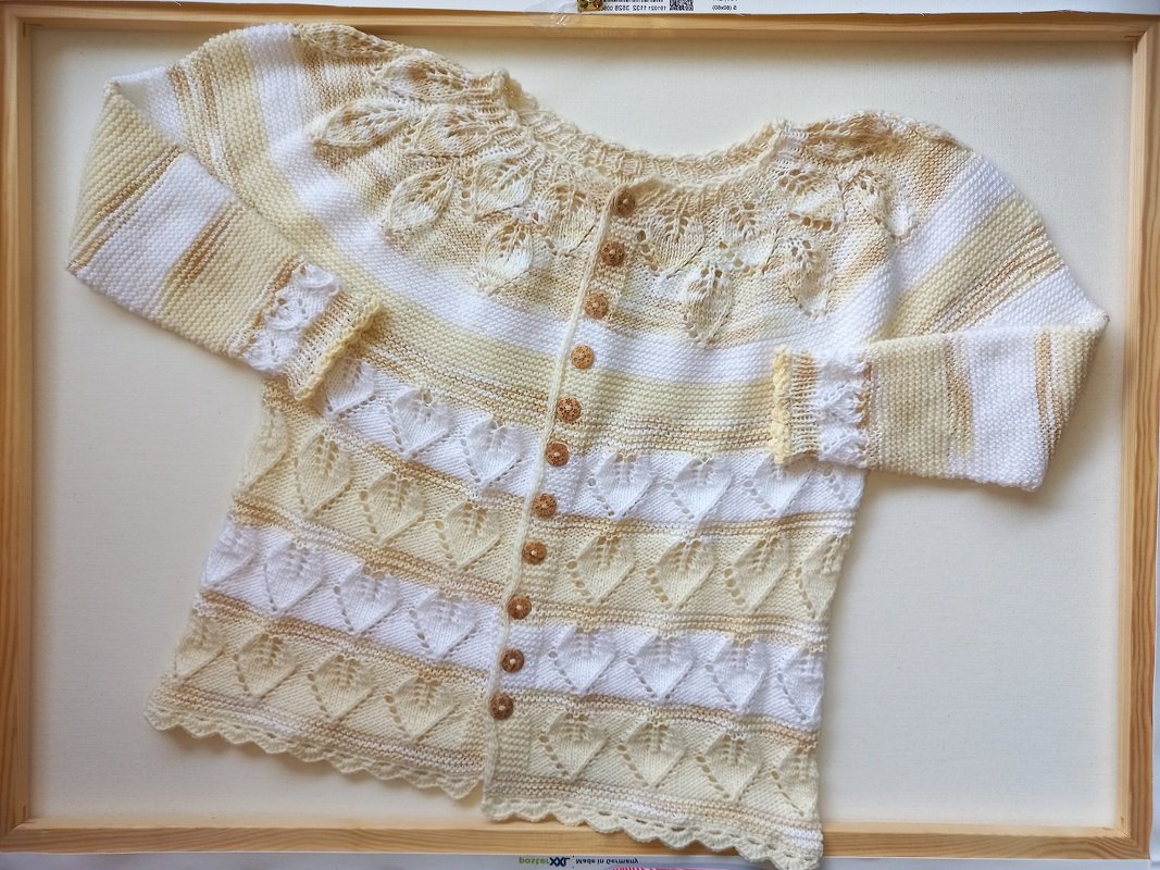 Gestrickte Babyjacke in Creme-Gelb mit Ajourblättern am Kragen, Herz-Ajourstreifen und Knopfleiste