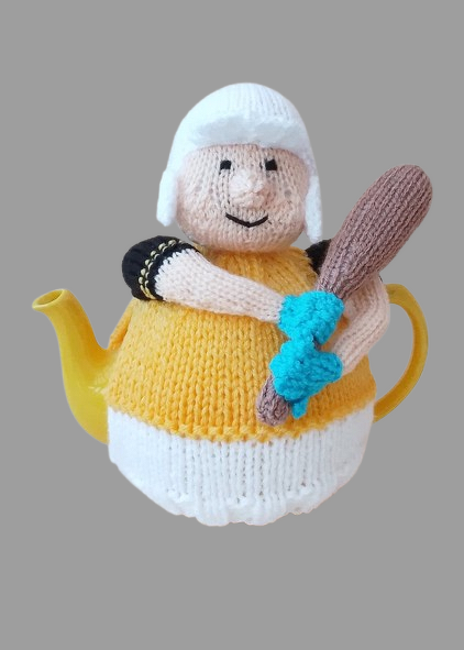 Knitted character tea cosy with white hat and turquoise gloves on a yellow teapot.