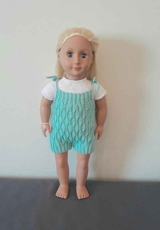 Puppe mit türkisfarbener Latzshorts mit Strukturmuster und weißem Kurzarmshirt