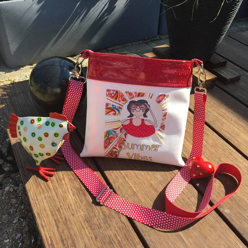 Weiße Umhängetasche mit rotem Glitzerabschluss, farbenfrohem Summer-Vibes-Motiv, gepunktetem Tragegurt, Herzanhänger und dekorativer Hühnerfigur