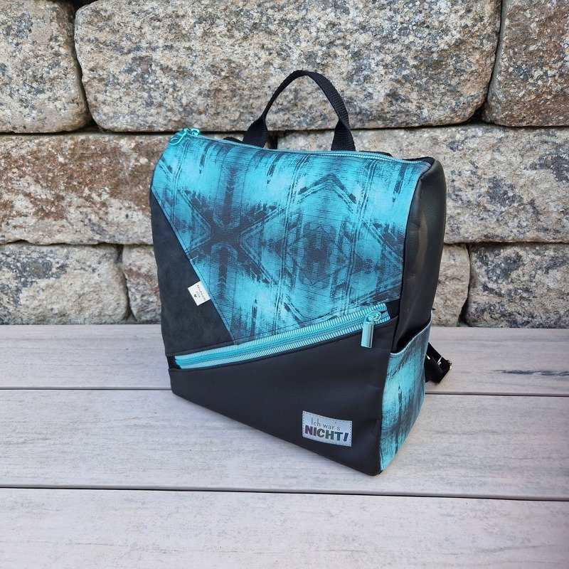 Kleiner türkis-schwarzer Rucksack mit diagonaler Reißverschlusstasche und Tragegriff