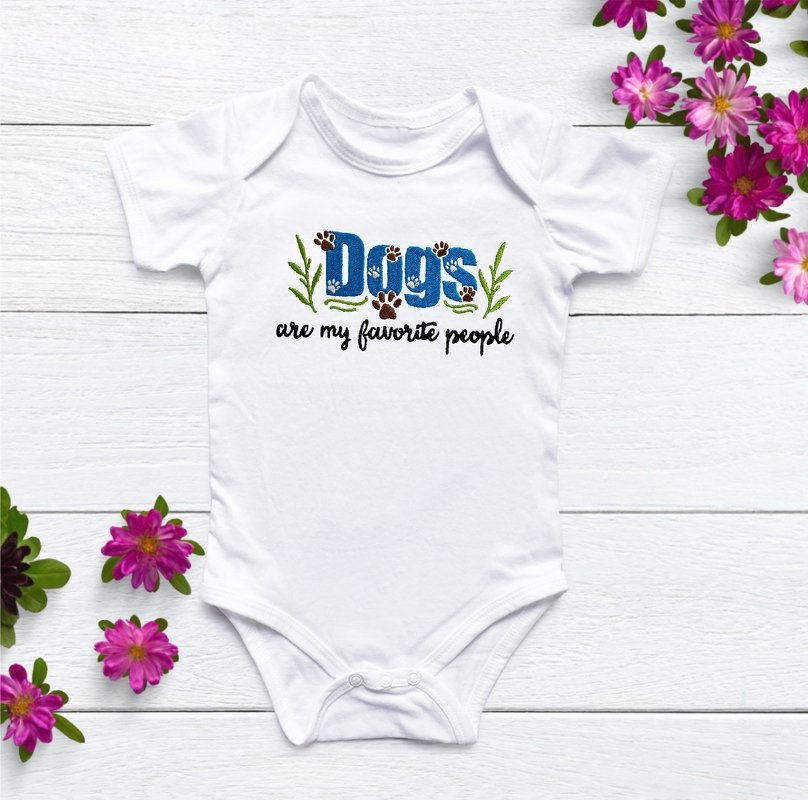 Weißer Babybody mit Stickmotiv 'Dogs' in blauen Blockbuchstaben, Pfoten und grünen Blattakzenten