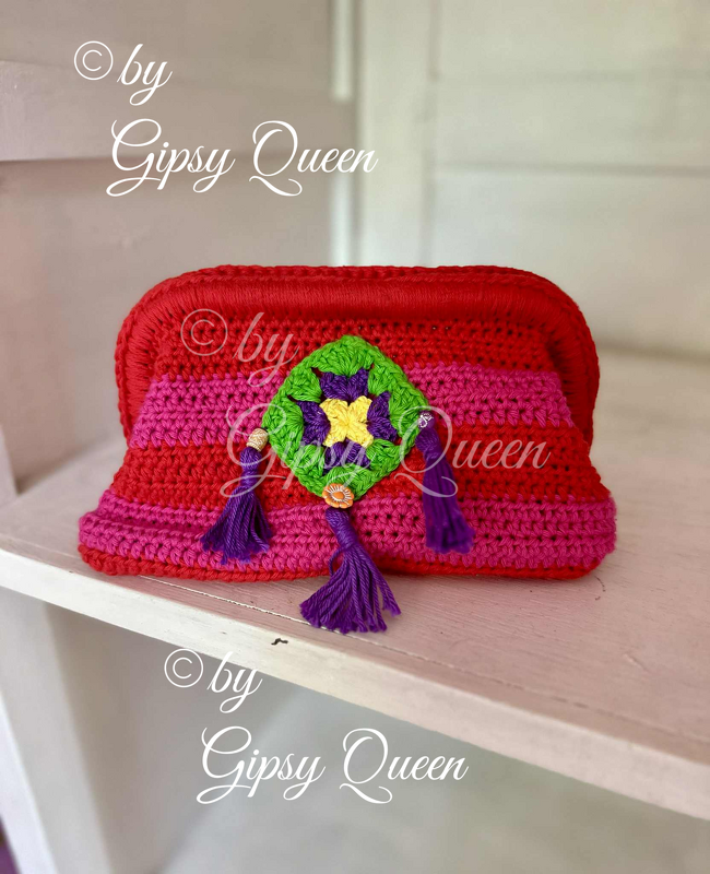 Rote und pinke gehäkelte Clutch mit grünem Granny
Square und violetten Quasten