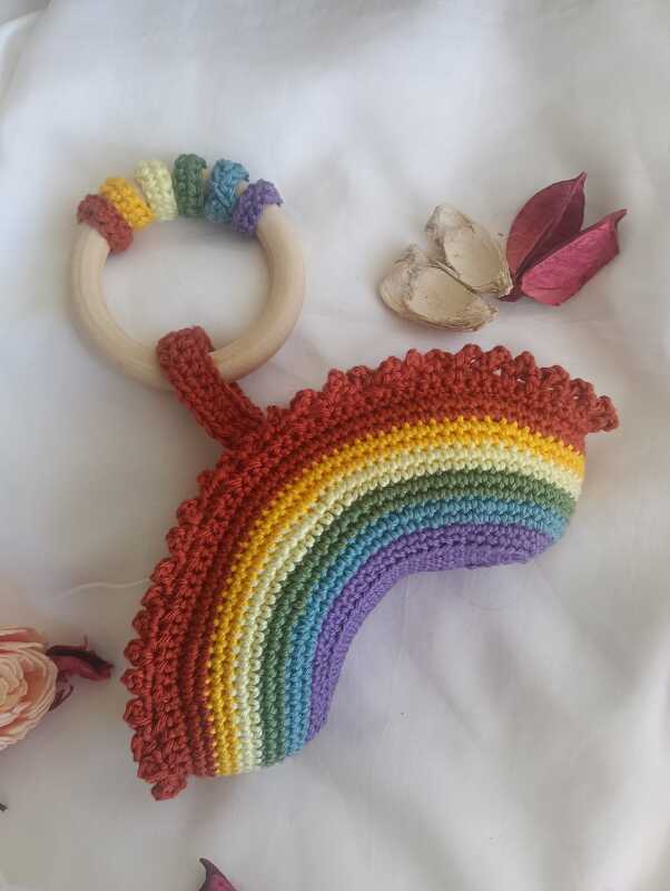 Gehäkelte Regenbogen-Rassel aus buntem Garn mit Holzring