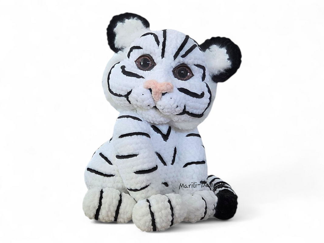 Seated crocheted white tiger amigurumi with black stripes and pink nose