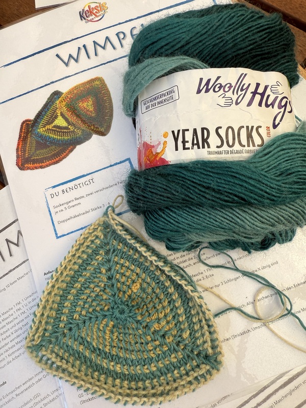 Tunesisch gehäkeltes Dreieck in Grün und Gelb, Garnknäuel und Wimpelanleitung