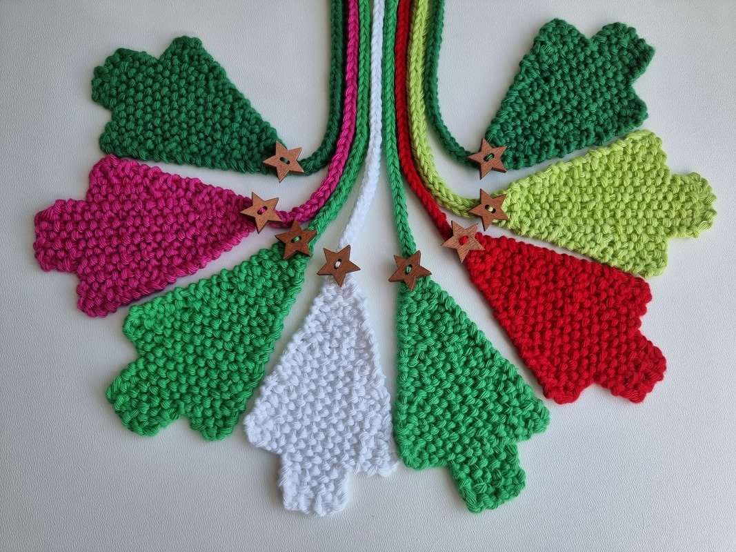 Bunte gestrickte Tannenbaum-Anhänger mit Holzsternknöpfen, fächerförmig angeordnet
