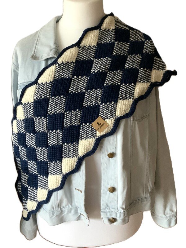 Tunesisch gehäkelter Schal in Marineblau und Creme mit Schachbrettmuster auf einer Schaufensterpuppe mit Jeansjacke