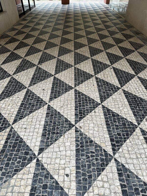 Black-and-white triangular tiles forming a repeating diamond grid pattern