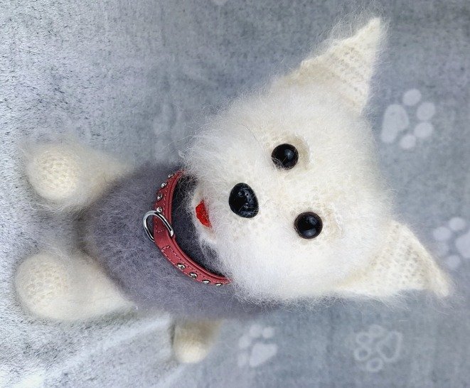 Gehäkelter weißer Amigurumi‑Hund mit rotem Halsband und grauem Pullover, Draufsicht