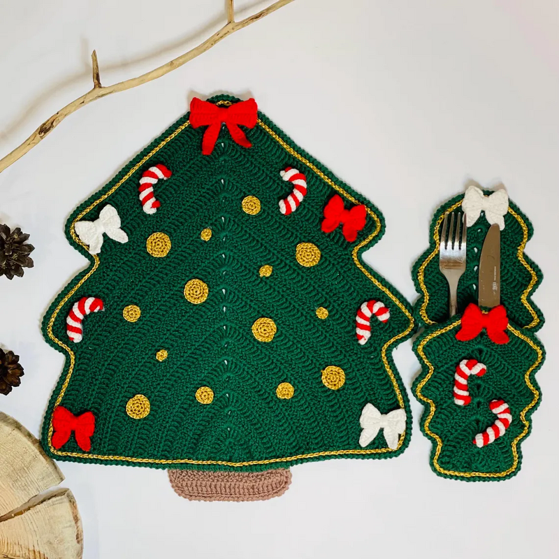 Green crocheted Christmas tree placemat with two matching small tree coasters decorated with bows, candy canes and gold accents.