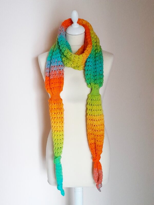 Schmaler gehäkelter Schal mit mehrfarbigem Farbverlauf auf weißer Schneiderbüste