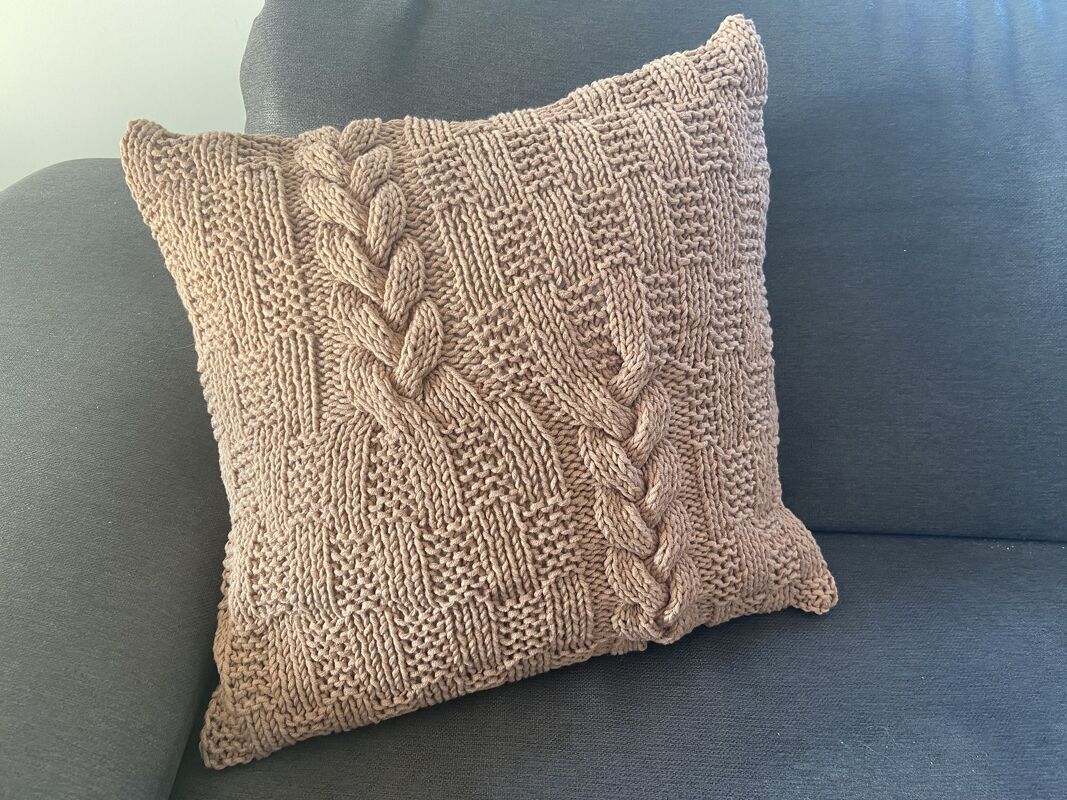 Quadratischer Kissenbezug in Taupe mit zwei Zopfreihen und kariertem Strukturmuster