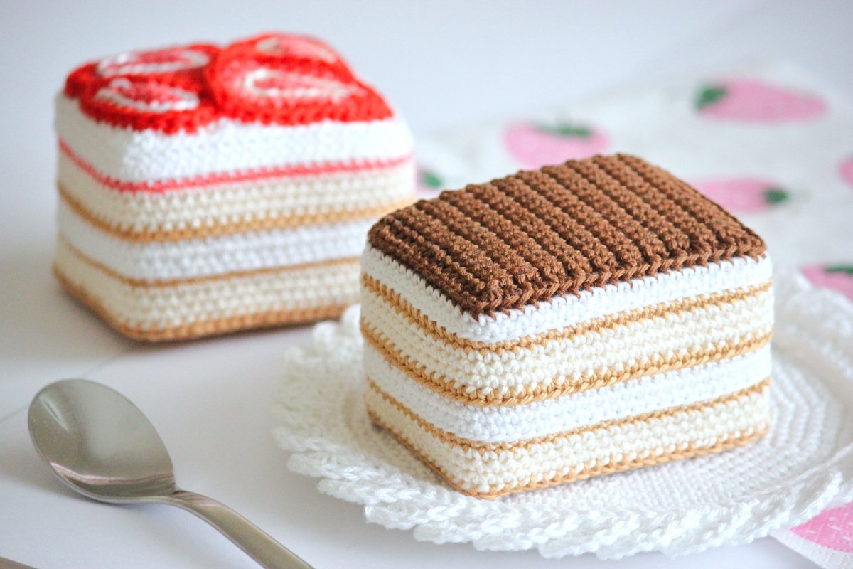 Rechteckiger gehäkelter Spielkuchen mit karamellfarbenen und weißen Streifen und brauner Oberseite