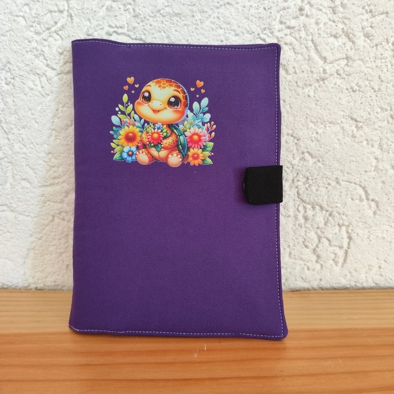 Lila Stoffhülle mit niedlicher Baby-Schildkröte und bunten Blumen, schwarzes Gummiband als Verschluss