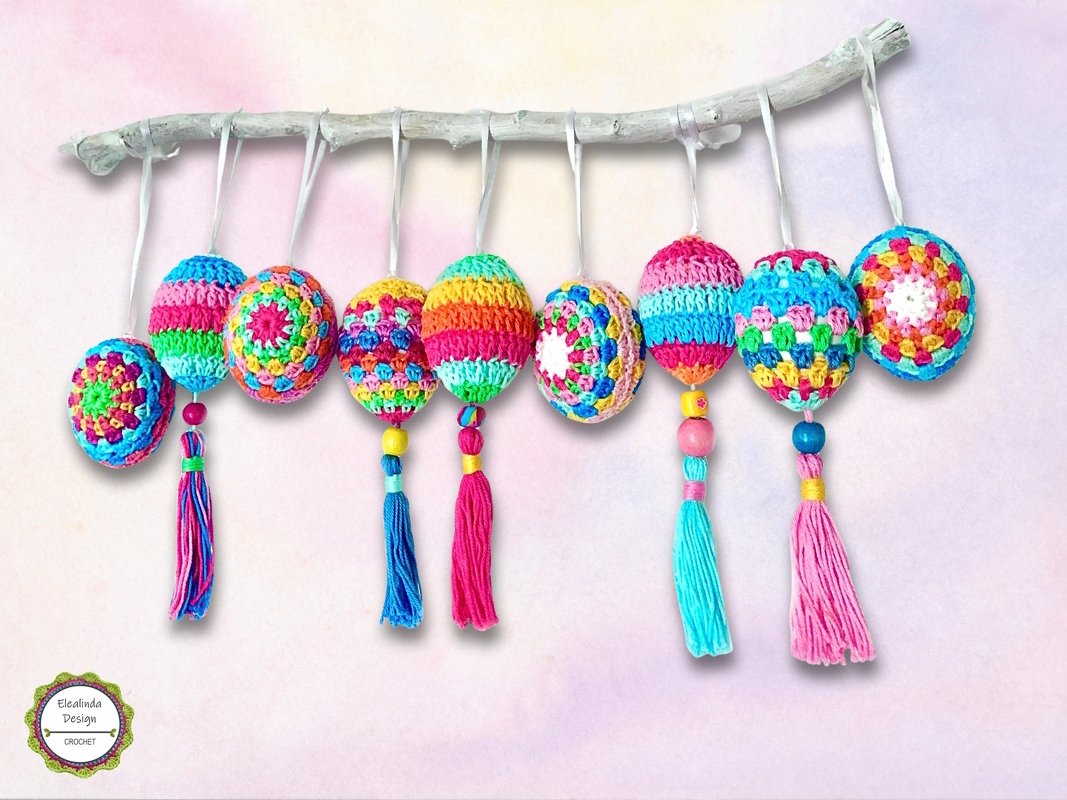 Colorful crocheted egg ornaments with tassels and beads hanging from a branch.