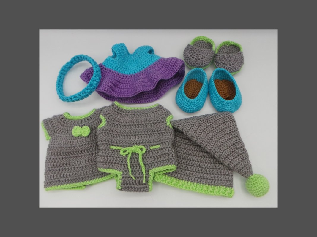 Gehäkeltes Amigurumi-Puppen-Set: Kleid, Oberteil, Strampler, Zipfelmütze, zwei Paar Schuhe und Stirnband in Grau, Türkis, Lila und Limette.