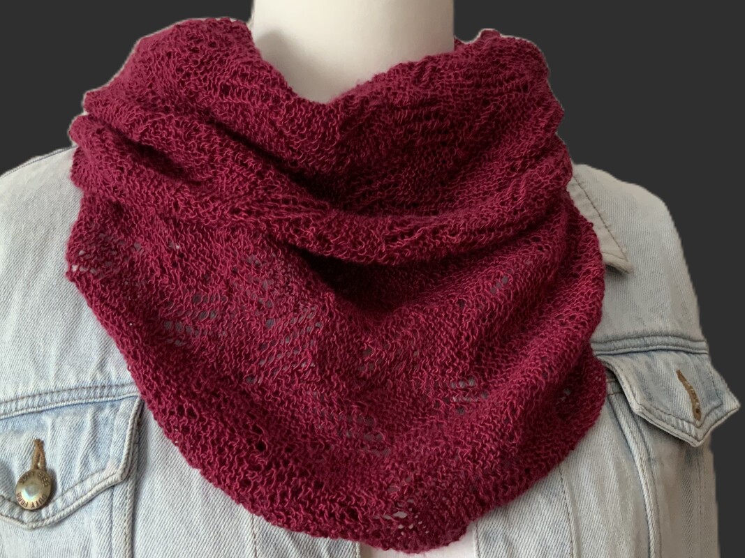 Bordeauxfarbenes gestricktes Dreieckstuch mit offenem Maschenbild auf Schaufensterpuppe über Jeansjacke