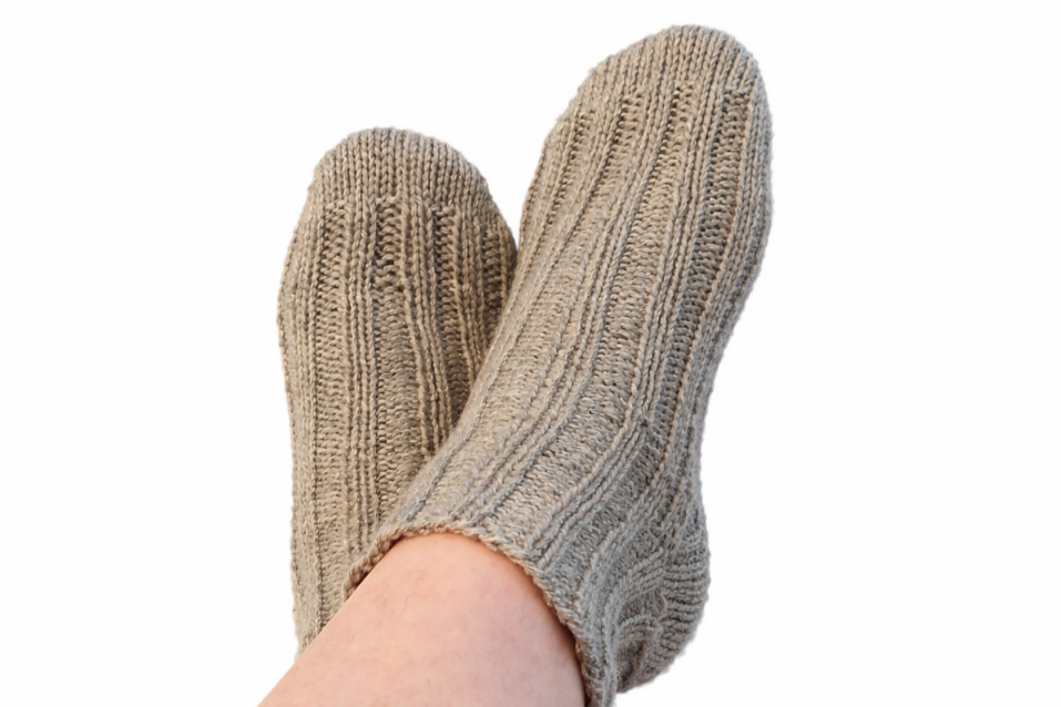 Knöchelhohe gestrickte Socken in beige-grau auf einem Fuß