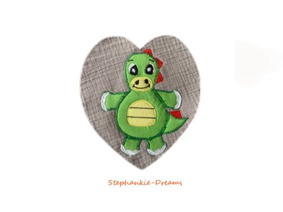 Playful green dinosaur embroidered on a heart-shaped fabric appliqué