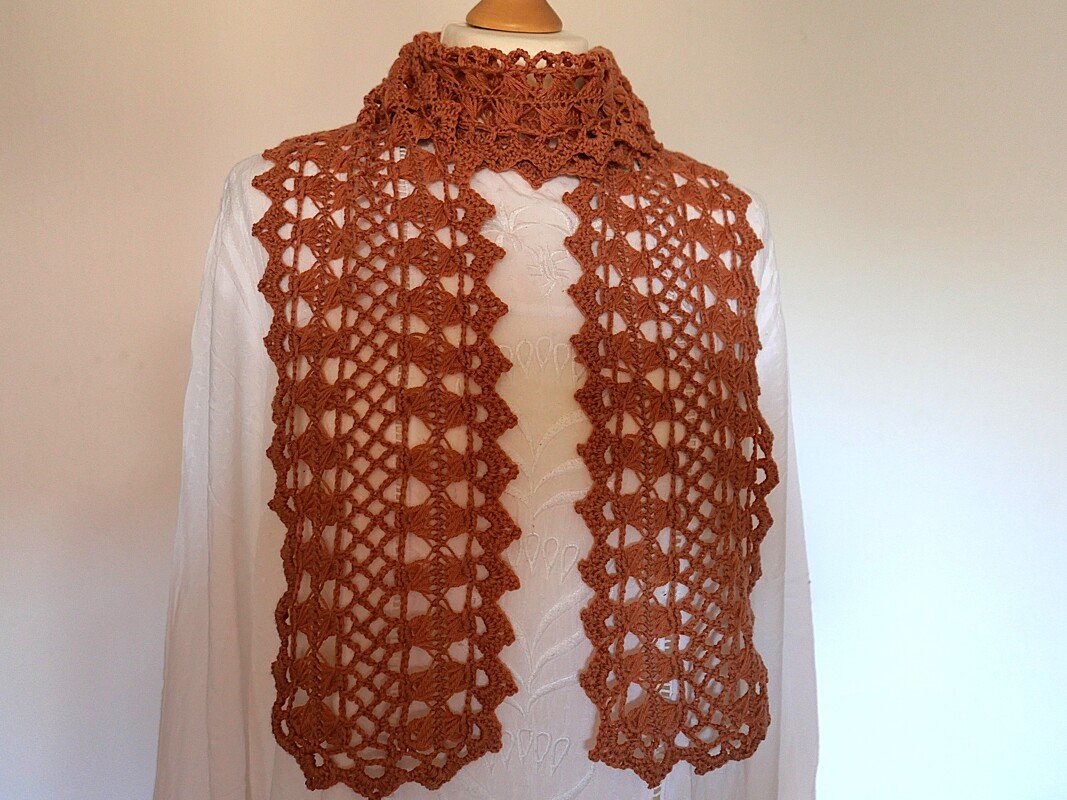 Gehäkelter Kragen in Terrakotta-Braun mit offenem Ajourmuster auf weißer Puppe